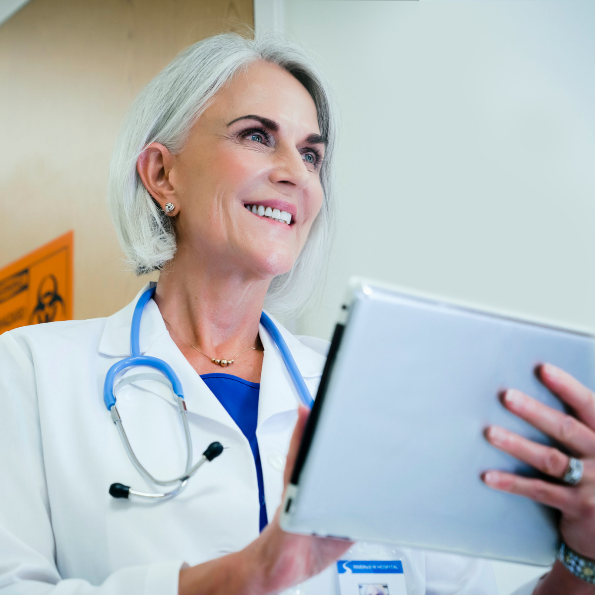 smiling female doctor looking at notes on a clipboard