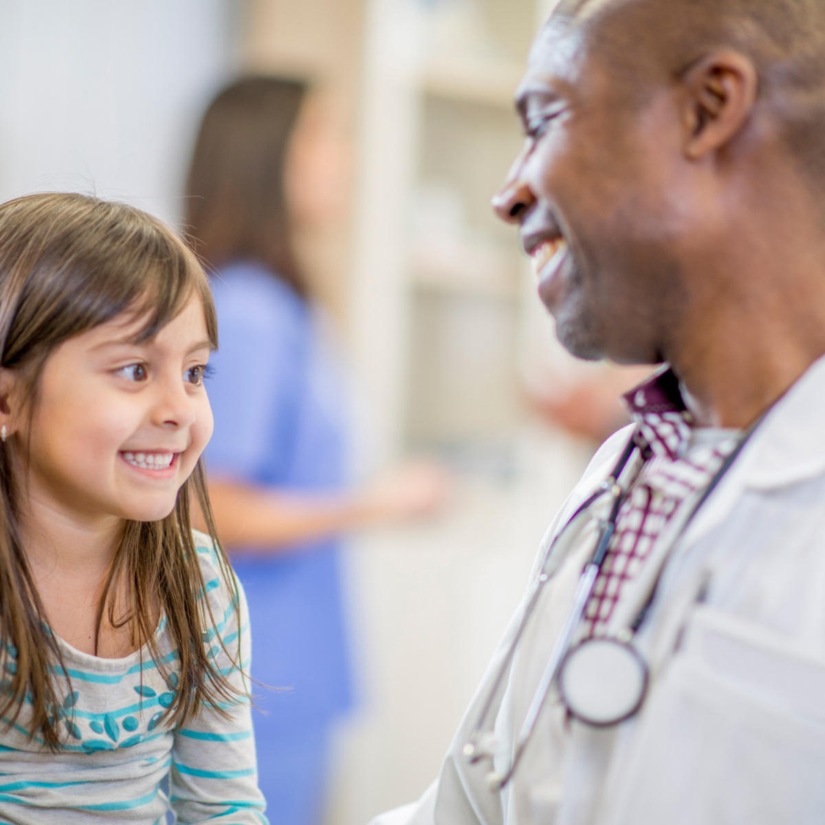 smiling male doctor with smiling female child